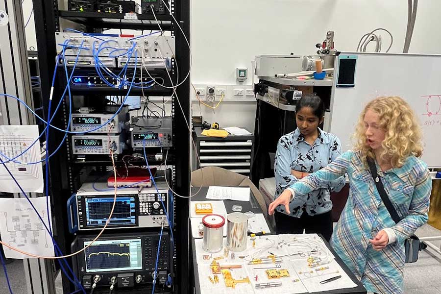 Honours students Aruna Sathyanarayanan Balaprabhavathi and Michelle Kazarinov exhibit the printed circuit boards and low temperature mounting pieces that are used to connect qubits to the coldest stage of the fridge (the mixing chamber)