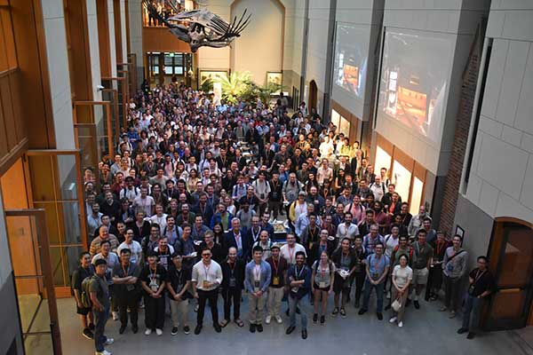 Group photo of QEC 2025 attendees, taken in the Yale Peabody Museum
